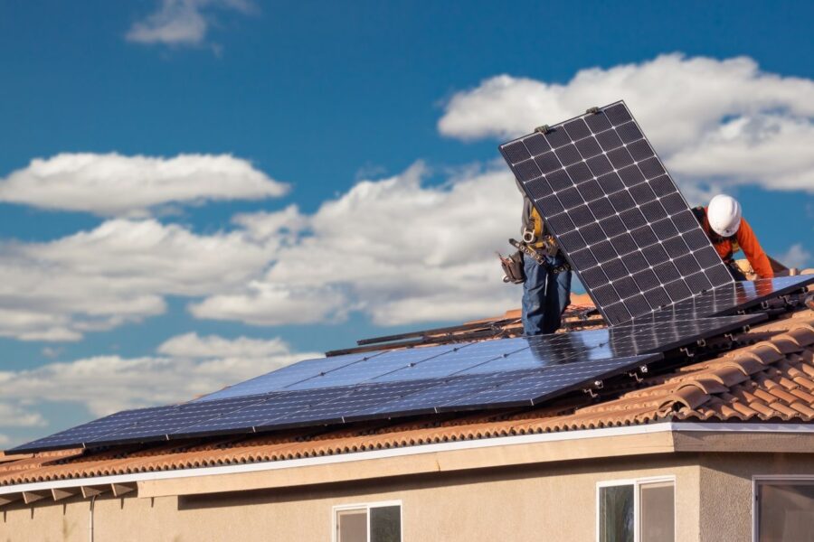 Solar panel installation on a tiled roof by professional installers under a clear sky on the Sunshine Coast, showcasing efficient renewable energy solutions for residential homes.
