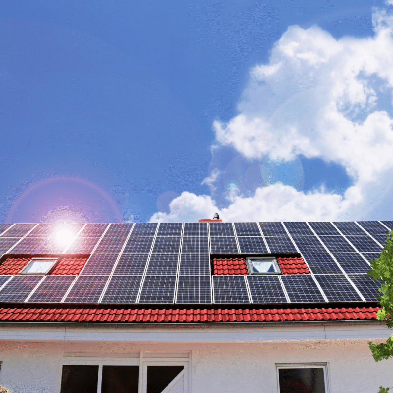 Modern home with a red-tiled roof fitted with solar panels under clear blue skies on the Sunshine Coast. TMEC Services – trusted solar panel installer – showcasing efficient solar panel installation for long-term energy savings.